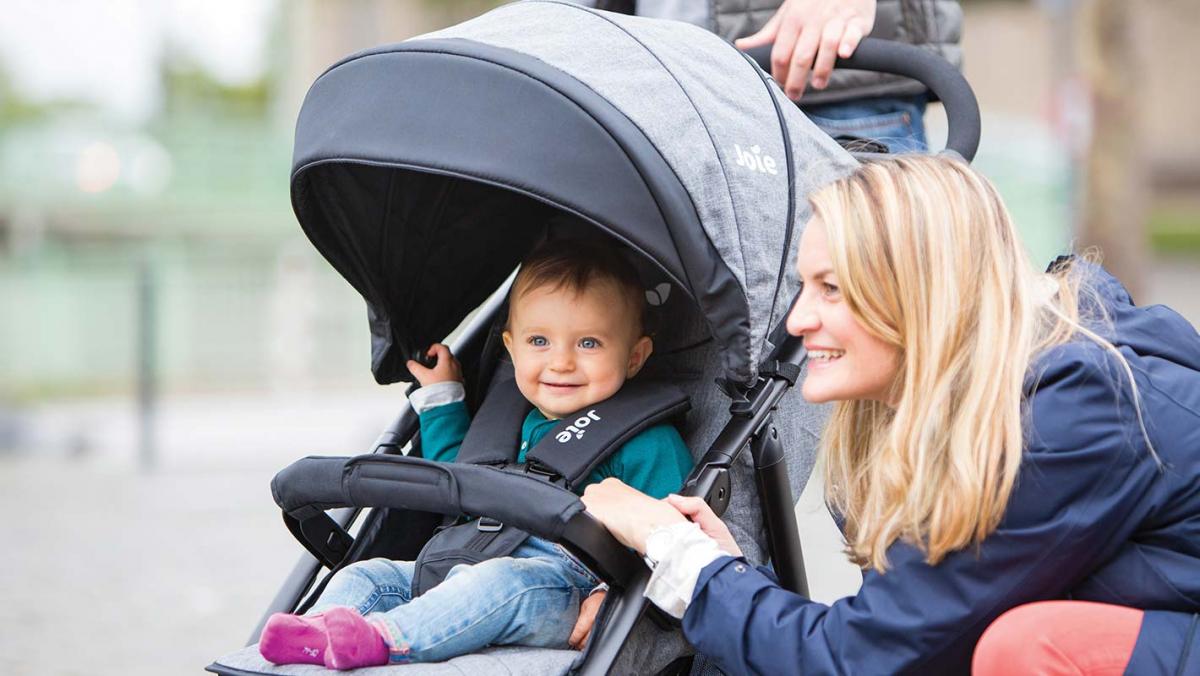 Mother playing with her child in a stroller