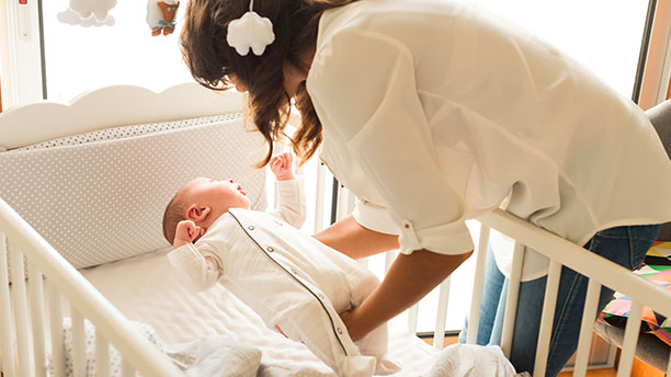Mother puts baby to sleep