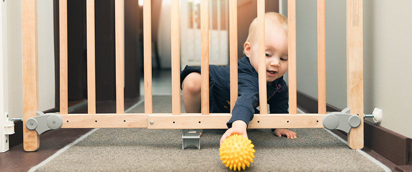 Baby crawling in front of a baby gate